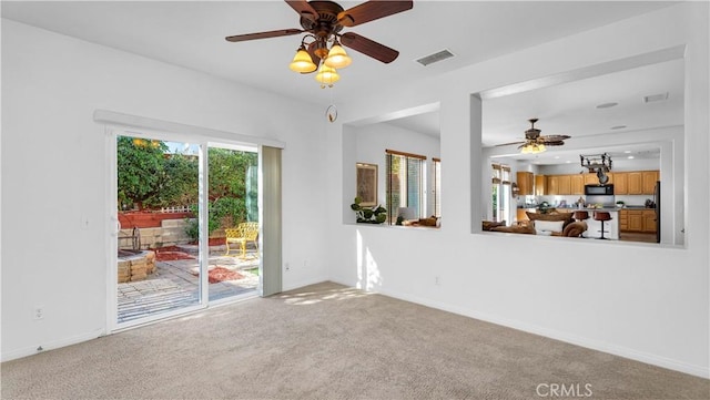 unfurnished living room featuring ceiling fan and carpet