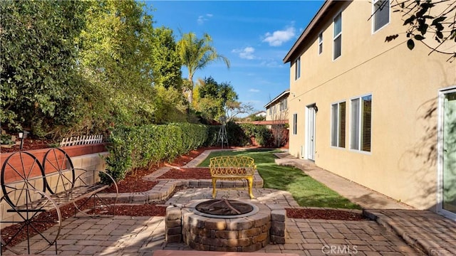 view of yard with a fenced backyard, a patio area, and an outdoor fire pit
