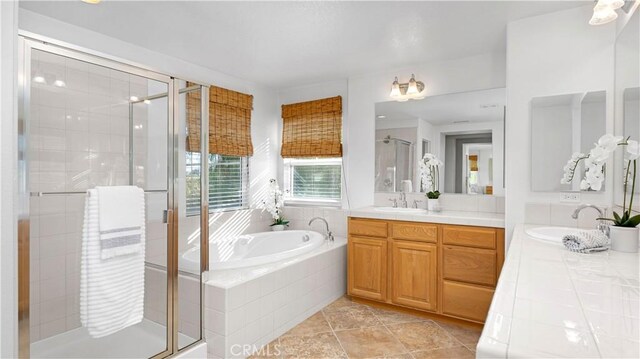 bathroom featuring plus walk in shower, tile patterned floors, and vanity