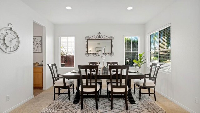 dining room with light colored carpet and plenty of natural light