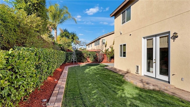 view of yard featuring a fenced backyard and french doors