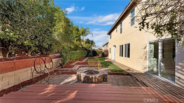 wooden terrace featuring an outdoor fire pit