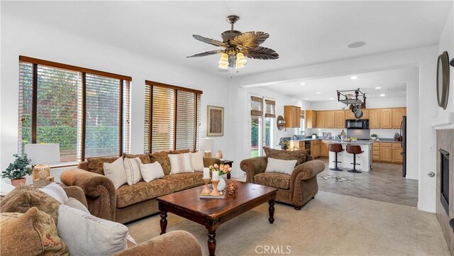 living room featuring ceiling fan and a healthy amount of sunlight