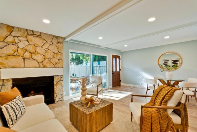 living room with a fireplace, light hardwood / wood-style floors, and beamed ceiling