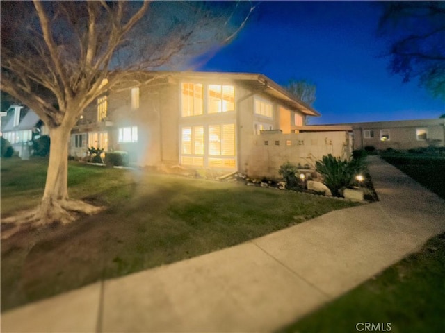 property exterior at twilight with a yard