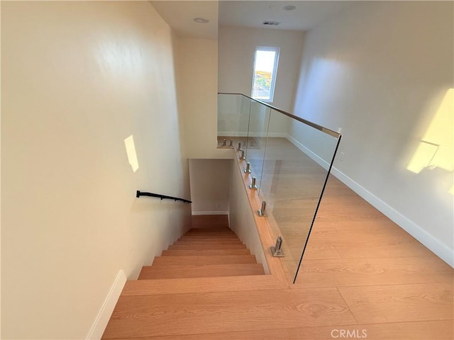 stairs featuring hardwood / wood-style floors