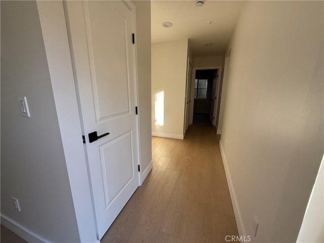 hallway with light hardwood / wood-style flooring