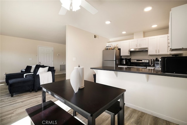 dining space with light hardwood / wood-style floors and ceiling fan