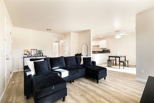 living room with ceiling fan and light hardwood / wood-style floors