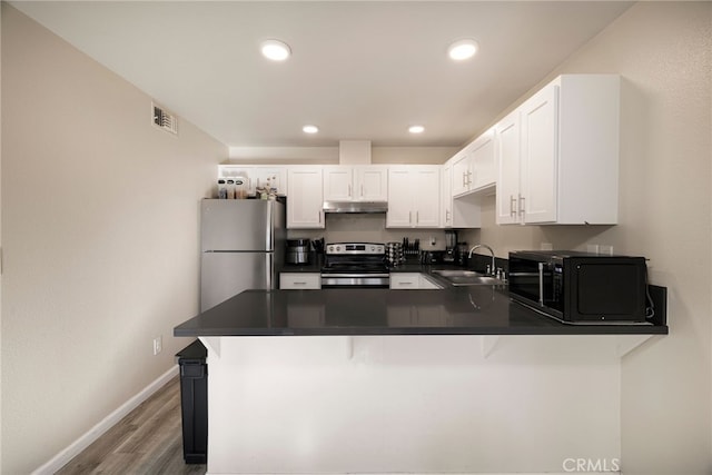 kitchen with kitchen peninsula, stainless steel appliances, white cabinets, and sink