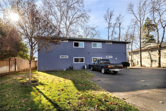 back of house featuring cooling unit and a yard