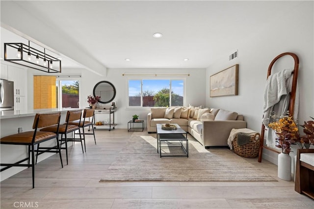 living room featuring light wood-type flooring and plenty of natural light