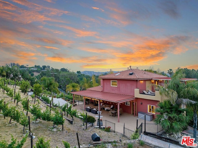 back house at dusk with a patio area