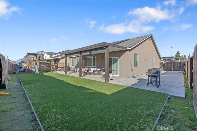 back of house with a playground, a patio area, and a lawn