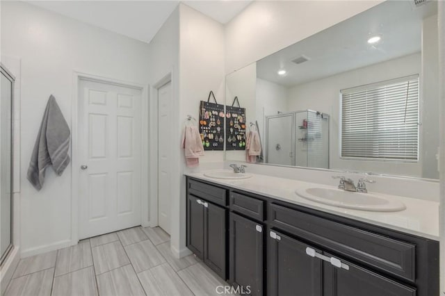 bathroom featuring vanity and a shower with shower door