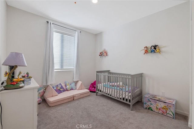 carpeted bedroom featuring a crib