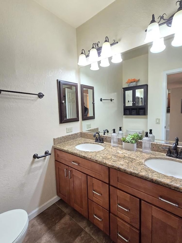 bathroom featuring vanity, toilet, and tile patterned flooring