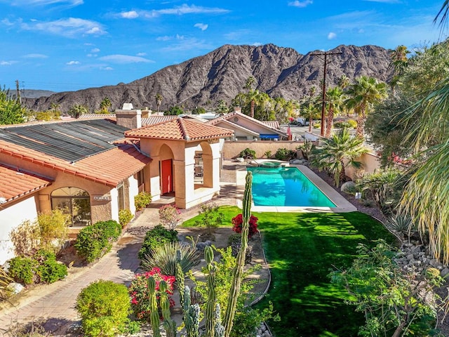 view of swimming pool with a lawn, a patio area, and a mountain view