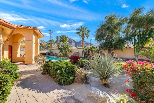 view of patio / terrace featuring a fenced in pool and a mountain view