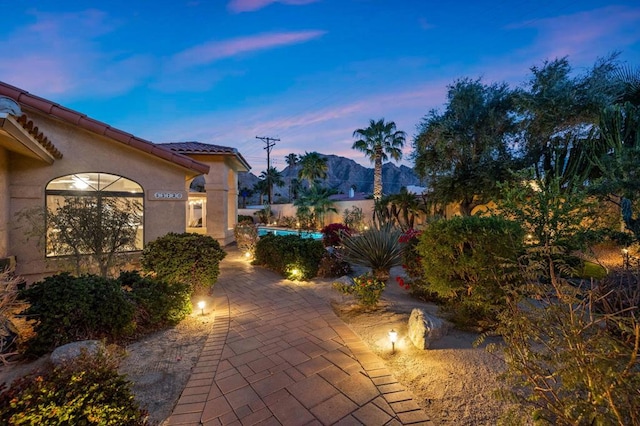 patio terrace at dusk featuring a mountain view