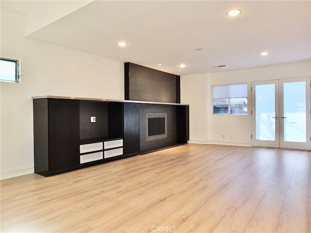 unfurnished living room with french doors and light wood-type flooring