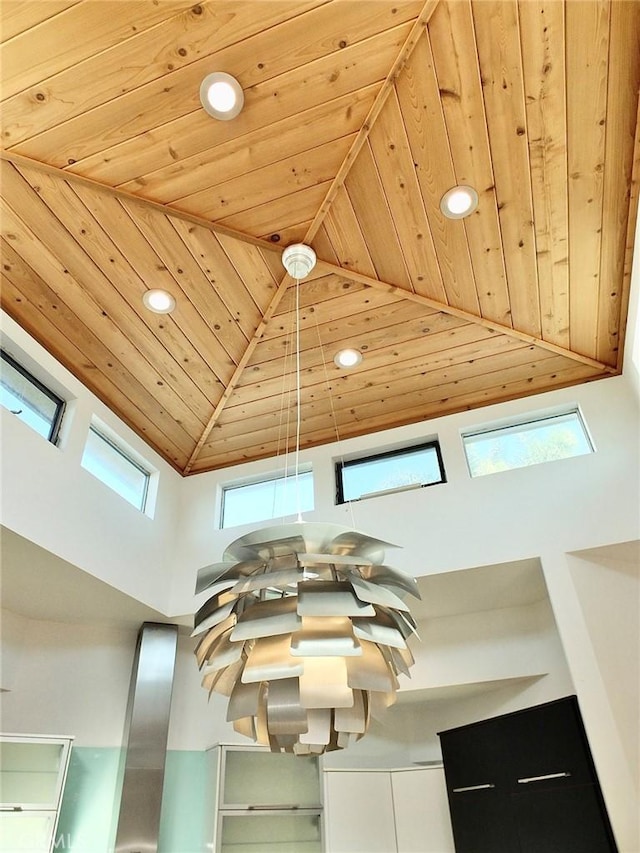 interior space with a healthy amount of sunlight, wood ceiling, and a towering ceiling