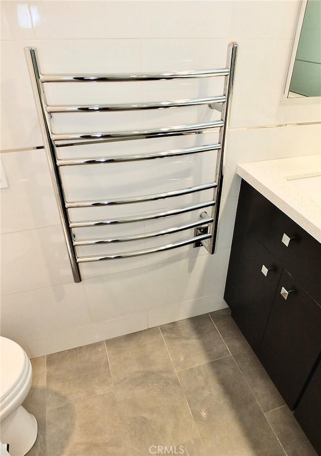 bathroom with vanity, toilet, radiator, and tile patterned flooring