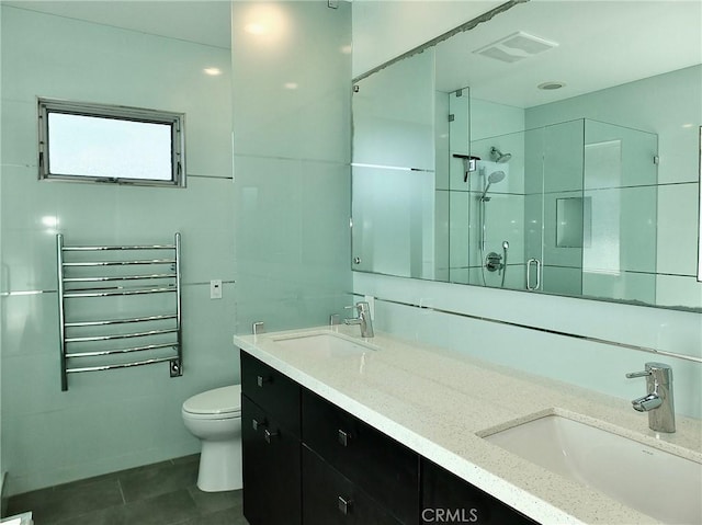 bathroom with vanity, radiator, a shower with door, and toilet