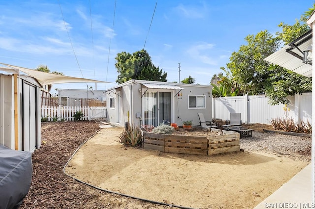 back of house featuring a storage unit