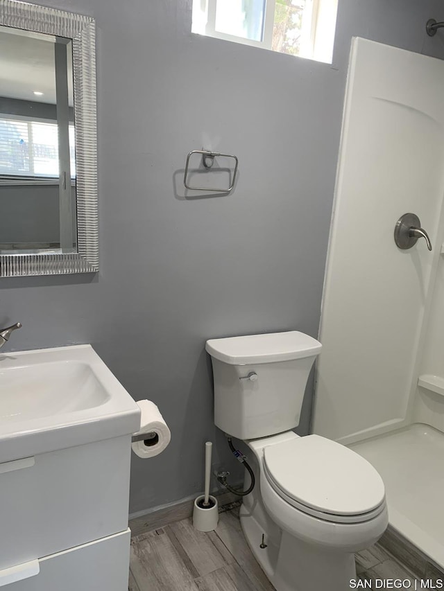 bathroom featuring toilet, vanity, and plenty of natural light