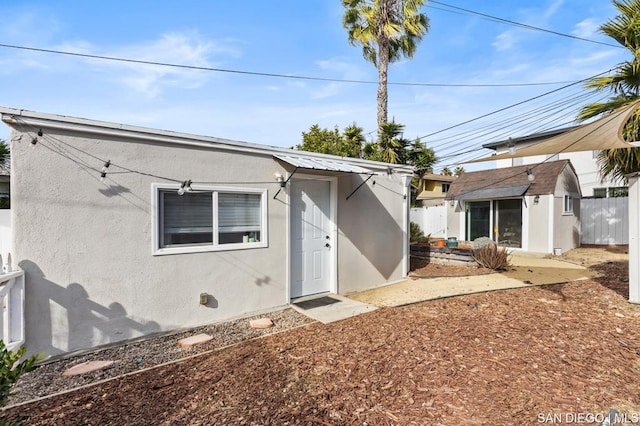 rear view of property featuring a storage shed