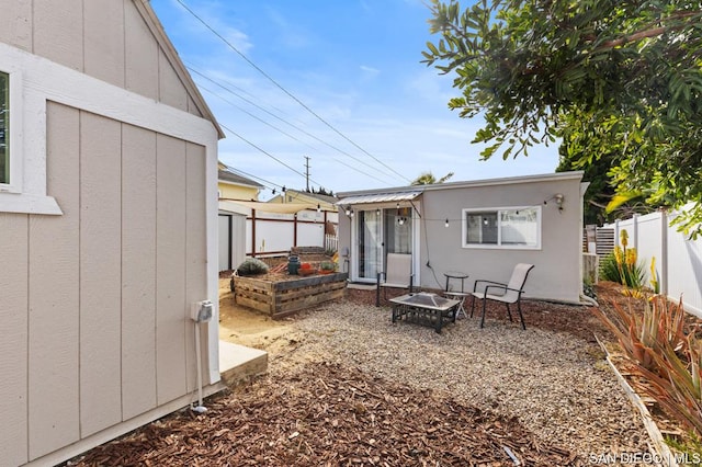 rear view of property featuring a fire pit