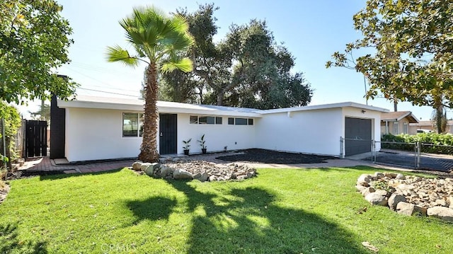 ranch-style house featuring a garage and a front lawn