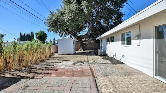 view of patio / terrace with a shed and central AC unit