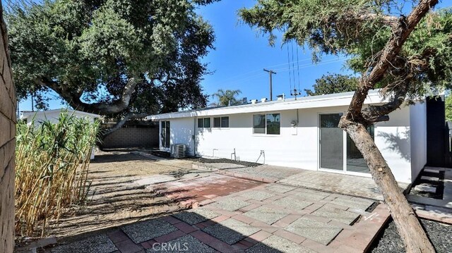 rear view of property featuring a patio and cooling unit