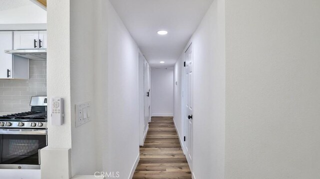 corridor with hardwood / wood-style flooring