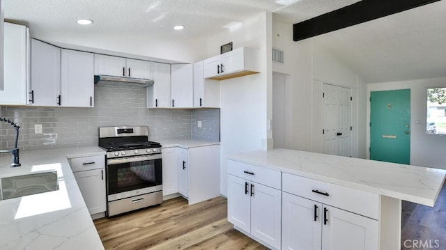 kitchen featuring white cabinetry, vaulted ceiling with beams, gas range, and sink