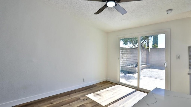 spare room with wood-type flooring, ceiling fan, and a textured ceiling