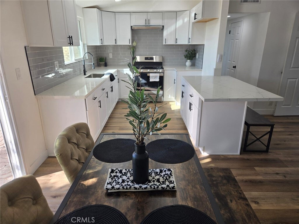5423 Benito St, Montclair, CA 91763 - kitchen with white cabinetry, stainless steel gas range oven, and sink