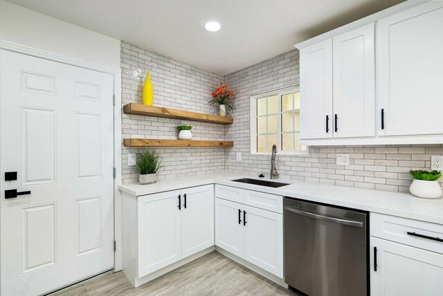 kitchen with tasteful backsplash, sink, white cabinets, and dishwasher