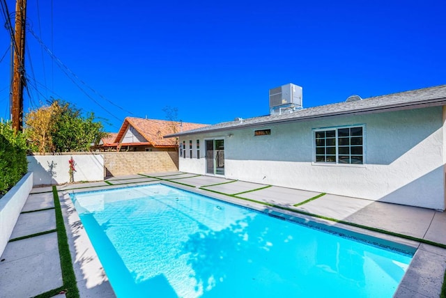 view of swimming pool with cooling unit and a patio