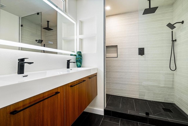 bathroom featuring vanity, tile patterned flooring, and tiled shower