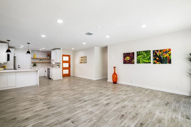 unfurnished living room with sink and light wood-type flooring