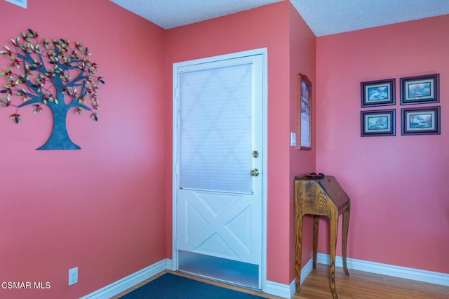 doorway to outside with hardwood / wood-style flooring and a textured ceiling