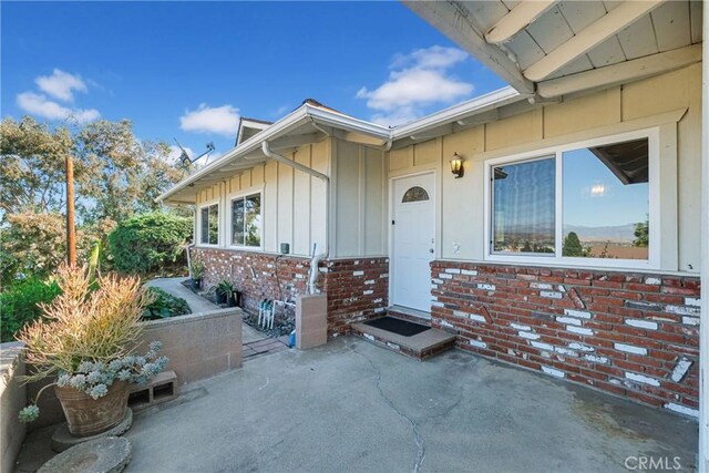 view of exterior entry with a patio area