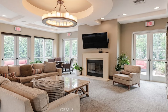 5550 Boardwalk Unit 102, Hawthorne, CA 90250 - living area with french doors, light colored carpet, a fireplace with flush hearth, a chandelier, and recessed lighting