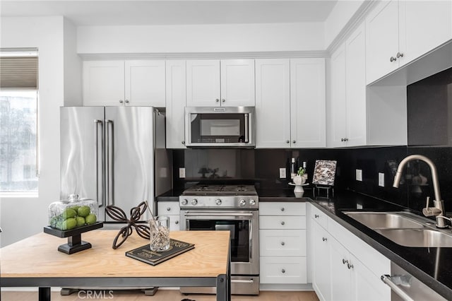 5550 Boardwalk Unit 102, Hawthorne, CA 90250 - kitchen with stainless steel appliances, a sink, white cabinets, and decorative backsplash