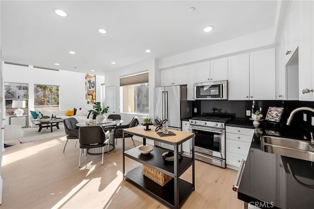 5550 Boardwalk Unit 102, Hawthorne, CA 90250 - kitchen with stainless steel appliances, a sink, white cabinetry, dark countertops, and recessed lighting