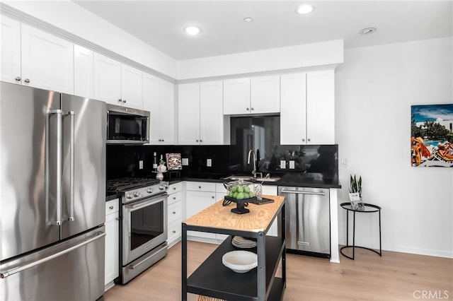 5550 Boardwalk Unit 102, Hawthorne, CA 90250 - kitchen with appliances with stainless steel finishes, a sink, tasteful backsplash, dark countertops, and white cabinets