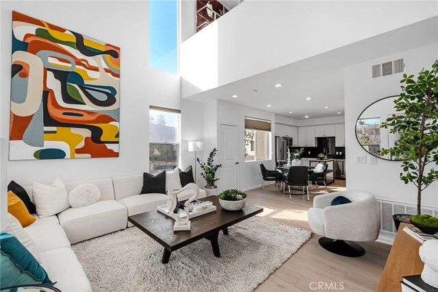 5550 Boardwalk Unit 102, Hawthorne, CA 90250 - living room featuring light wood-style floors, recessed lighting, and a towering ceiling
